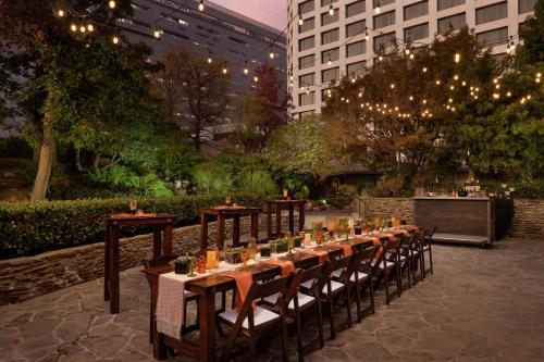 a long table with chairs and lights in a courtyard at Doubletree by Hilton Los Angeles Downtown in Los Angeles