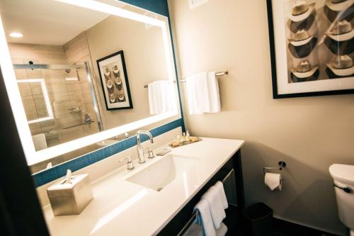 ein Badezimmer mit einem Waschbecken, einem Spiegel und einem WC in der Unterkunft Doubletree By Hilton Lubbock - University Area in Lubbock