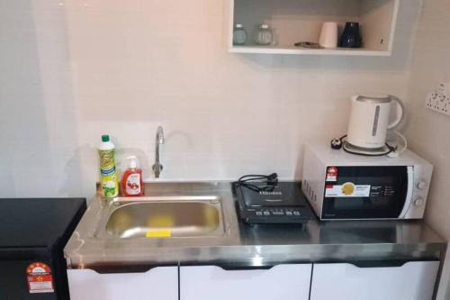a kitchen counter with a sink and a microwave at Sky Trees Netflix and Facilities at Bukit Indah in Johor Bahru