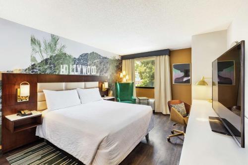 Cette chambre comprend un lit et une télévision. dans l'établissement Hilton Garden Inn Los Angeles / Hollywood, à Los Angeles