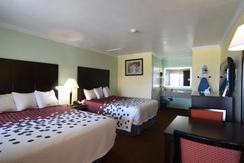 a hotel room with two beds and a table at Morro Bay Beach Inn in Morro Bay