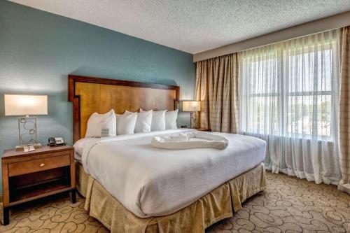 - une chambre avec un grand lit et une grande fenêtre dans l'établissement Embassy Suites Memphis, à Memphis