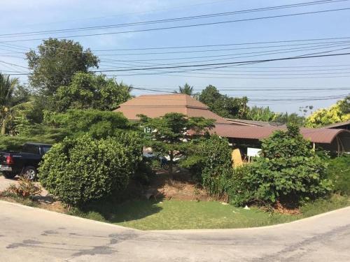 Una casa con árboles y un camión estacionado frente a ella. en บ้านคลองชล 