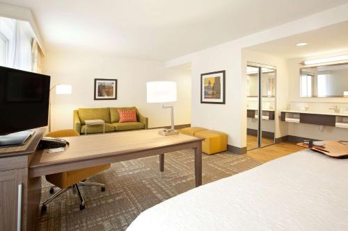 a hotel room with a desk and a living room at Hampton Inn & Suites - Minneapolis/Downtown in Minneapolis
