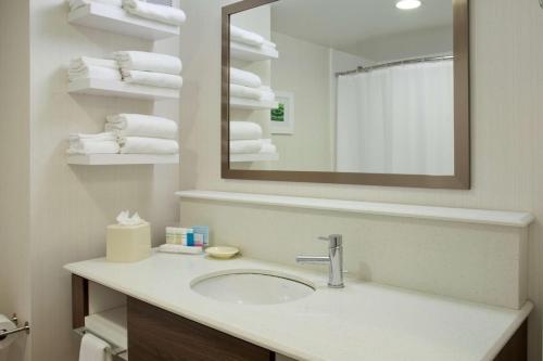 a bathroom with a sink and a mirror and towels at Hampton Inn & Suites - Minneapolis/Downtown in Minneapolis