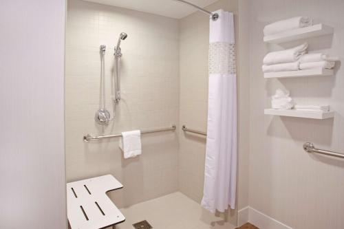 a bathroom with a shower with a toilet and towels at Hampton Inn & Suites - Minneapolis/Downtown in Minneapolis