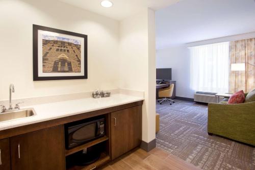 a kitchen with a sink and a living room at Hampton Inn & Suites - Minneapolis/Downtown in Minneapolis