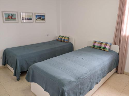 duas camas sentadas uma ao lado da outra num quarto em Apartament Maia Ocean em Corralejo