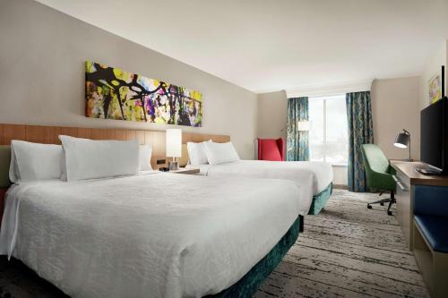 a hotel room with two beds and a television at Hilton Garden Inn New Orleans Convention Center in New Orleans