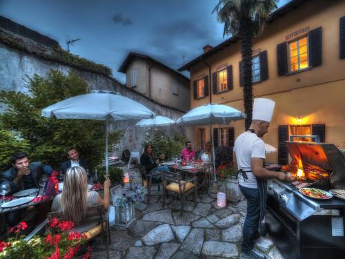 a group of people sitting around a patio with a grill at VILLA VINICIA, pool, jacuzzi, airco in Domaso