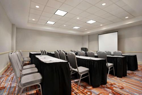 a conference room with a table and chairs and a screen at Hilton Garden Inn New Orleans Convention Center in New Orleans