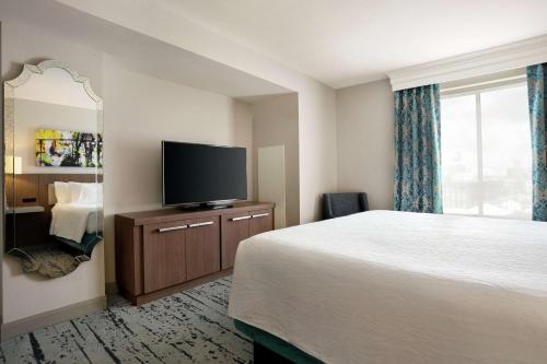 a hotel room with a bed and a flat screen tv at Hilton Garden Inn New Orleans Convention Center in New Orleans