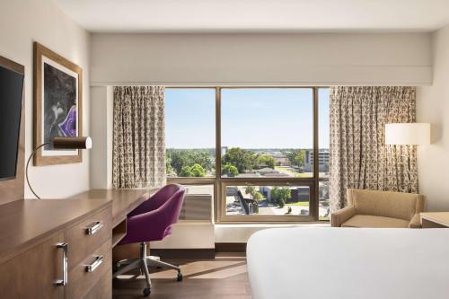 a hotel room with a bed and a large window at DoubleTree by Hilton New Orleans Airport in Kenner