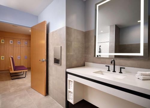 La salle de bains est pourvue d'un lavabo et d'un miroir. dans l'établissement Canopy by Hilton New Orleans Downtown, à La Nouvelle-Orléans