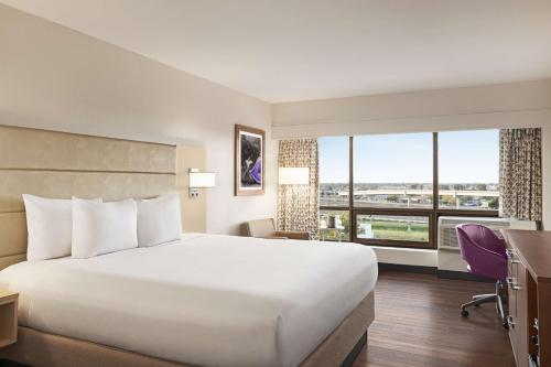 DoubleTree by Hilton New Orleans Airport في كينير: غرفة فندقية بسرير كبير ونافذة كبيرة