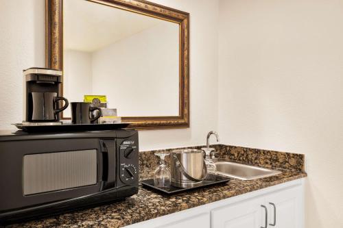 a kitchen counter with a microwave and a sink at DoubleTree by Hilton New Orleans Airport in Kenner