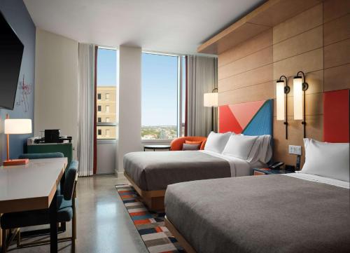 Cette chambre comprend deux lits et un bureau. dans l'établissement Canopy by Hilton New Orleans Downtown, à La Nouvelle-Orléans
