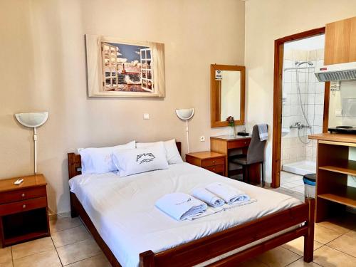 a bedroom with a bed with two towels on it at Gradma Katina in Platanias