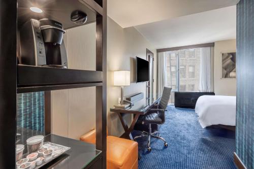 a hotel room with a bed and a desk at Hilton New York Fashion District in New York