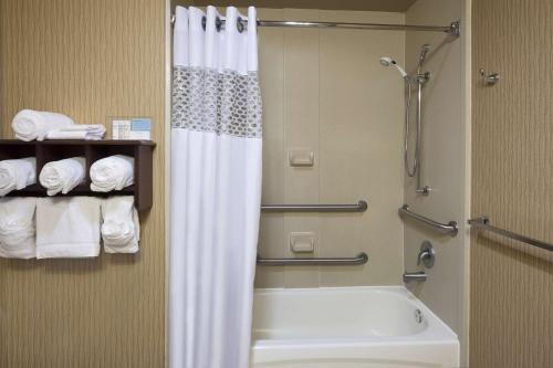 a bathroom with a shower and a tub and a toilet at Hampton Inn West Palm Beach Central Airport in West Palm Beach