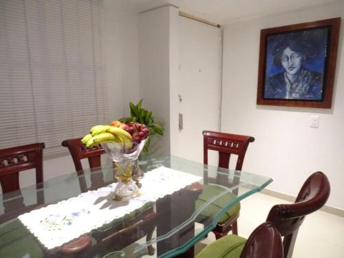 a glass table with a vase of fruit on it at Casa tranquila in Mosquera