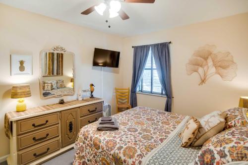 a bedroom with a bed and a dresser and a mirror at St Simons Island Condo with Deck and Outdoor Shower in Saint Simon Mills