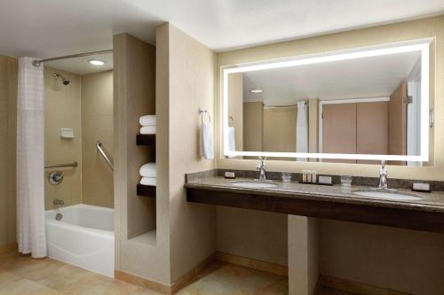 a bathroom with two sinks and a large mirror at Embassy Suites by Hilton Phoenix Tempe in Tempe