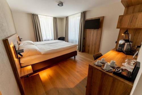 Schlafzimmer mit einem Bett und Holzboden in der Unterkunft ZIEGELHÜSI Hotel, Stettlen bei Bern in Bern