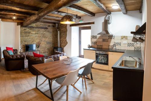 盧戈的住宿－Casa Liñeiras，厨房以及带木桌和椅子的客厅。