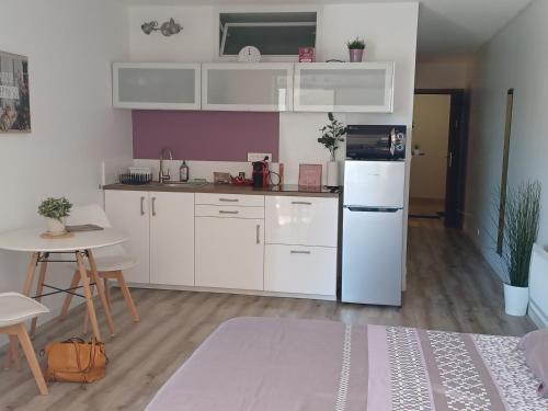 une cuisine avec des armoires blanches et un réfrigérateur blanc dans l'établissement Les Embiez, à Six-Fours-les-Plages