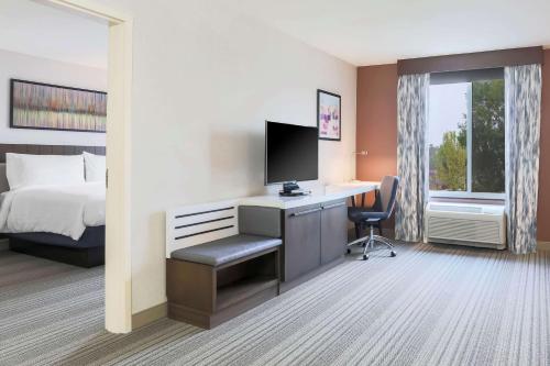 a hotel room with a bed and a desk with a computer at Hilton Garden Inn Reno in Reno