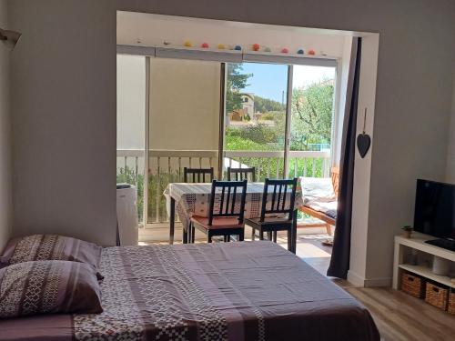 une chambre avec un lit et un balcon avec une table et des chaises dans l'établissement Les Embiez, à Six-Fours-les-Plages