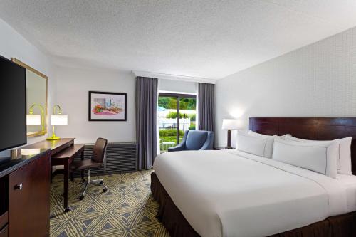 Habitación de hotel con cama grande y escritorio. en DoubleTree by Hilton Pittsburgh - Meadow Lands, en Washington
