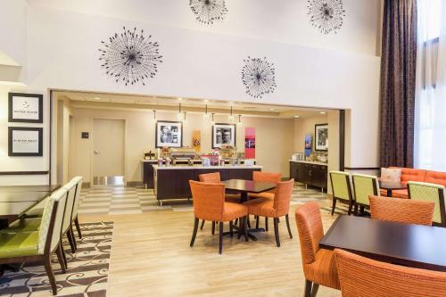 a restaurant with tables and chairs and a counter at Hampton Inn & Suites San Bernardino in San Bernardino