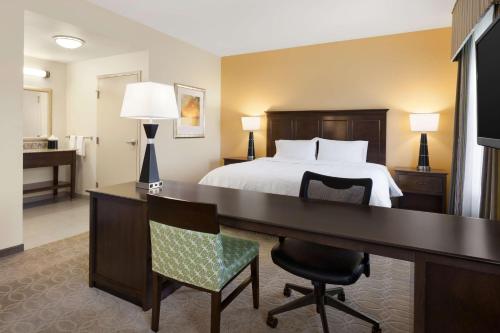 Habitación de hotel con cama y escritorio con dormitorio en Hampton Inn & Suites San Bernardino, en San Bernardino