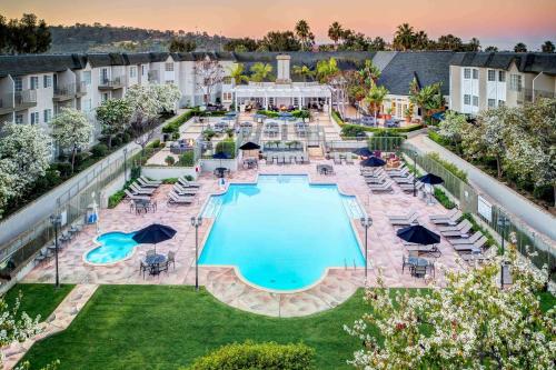 - une vue sur la piscine d'un hôtel avec des chaises et des tables dans l'établissement Hilton San Diego/Del Mar, à San Diego