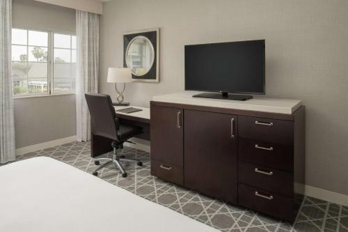 a hotel room with a desk with a flat screen tv at Hilton San Diego/Del Mar in San Diego