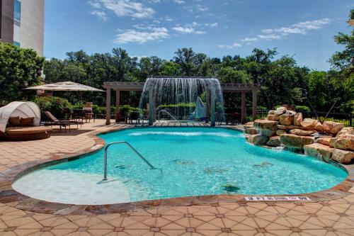 a swimming pool with a waterfall in a backyard at Hampton Inn & Suites Boerne in Boerne
