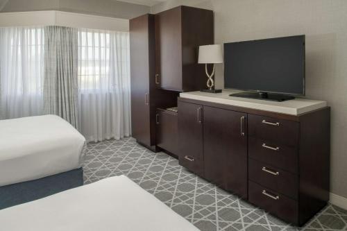 a hotel room with a bed and a flat screen tv at Hilton San Diego/Del Mar in San Diego