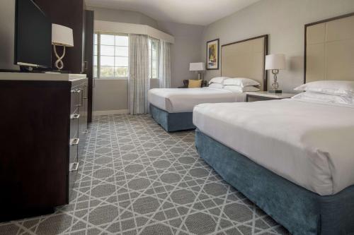 a hotel room with two beds and a television at Hilton San Diego/Del Mar in San Diego