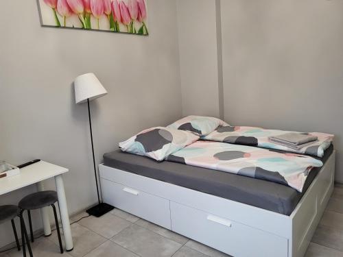 1 dormitorio con 1 cama con lámpara y escritorio en Pokój gościnny, en Żyrardów