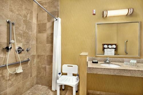 a bathroom with a shower and a toilet and a sink at Hampton Inn Shawnee in Shawnee