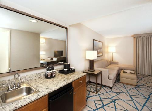 a hotel room with a sink and a living room at Embassy Suites by Hilton Seattle Bellevue in Bellevue