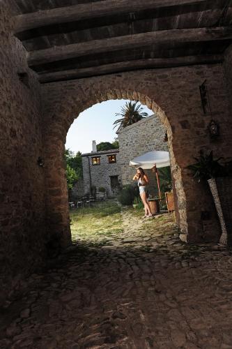a woman standing in an archway with an umbrella at Antica Locanda Lunetta in Màndas