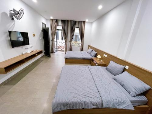 a bedroom with two beds and a flat screen tv at Cá House in Quy Nhon