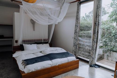 a bedroom with a bed and a large window at Kaliwa Lodge in Moshi