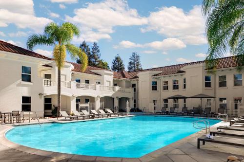 uma piscina em frente a um edifício com um resort em Hayes Mansion San Jose, Curio Collection by Hilton em San Jose