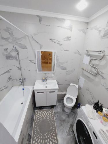 Апартаменты в ЖК Only Sun في Prigorodnyy: حمام مع مرحاض وحوض استحمام ومغسلة