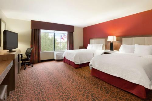a hotel room with two beds and a flat screen tv at Hampton Inn Wichita Falls-Sikes Senter Mall in Wichita Falls
