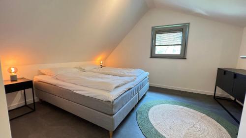 um pequeno quarto com uma cama e uma janela em VILLA ARYVE in See-, Strand- und Golfplatznähe inklusive NETFLIX, Bad en Suite und Wohlfühlgarantie em Dirkshorn